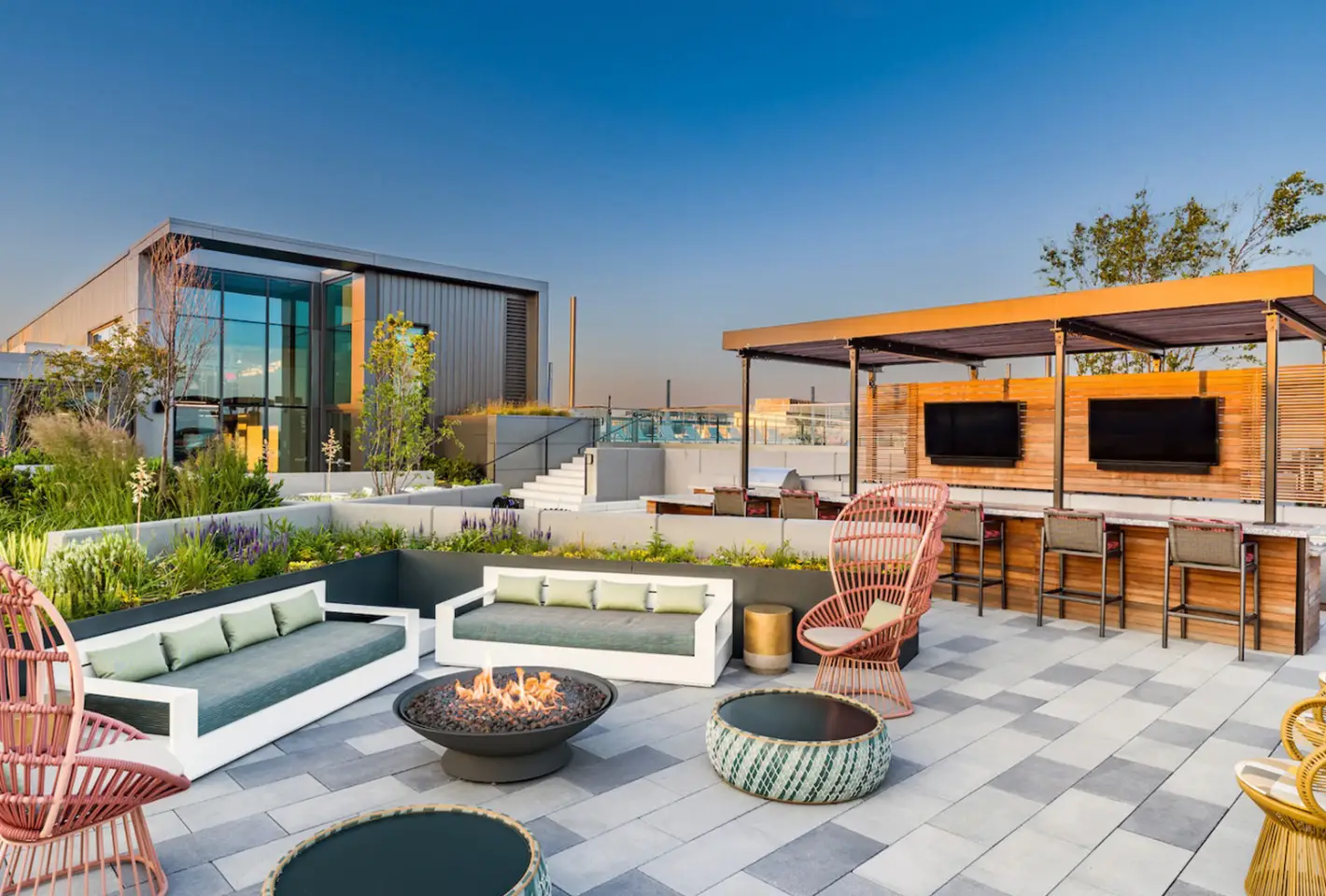 Elegant rooftop retreat with comfortable seating, firepit, and modern design overlooking urban landscape