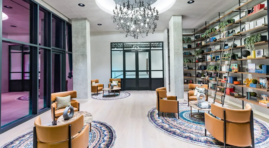 Inviting seating area with modern leather chairs, artistic rugs, and unique chandelier centerpiece