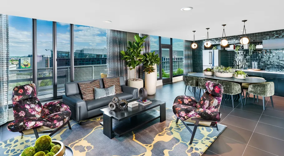 Chic apartment interior featuring bold floral motif chairs, modern decor, and expansive glass windows
