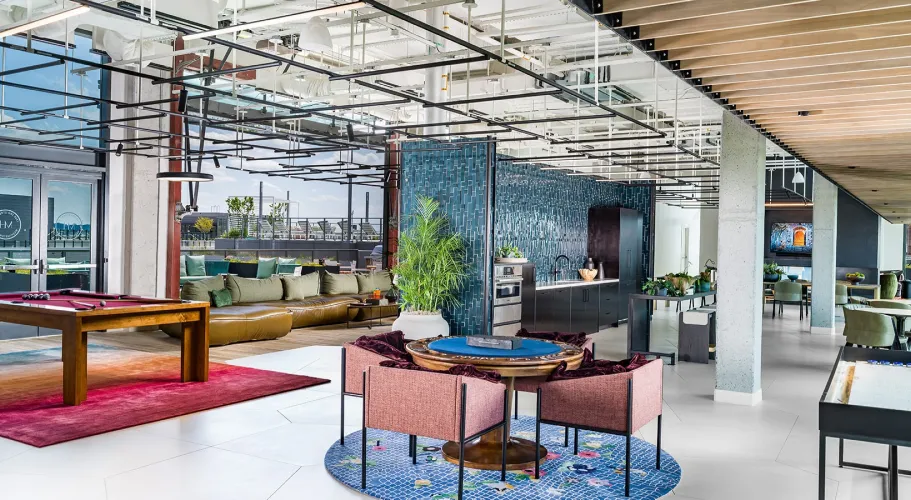 Chic entertainment space with poker table, billiards, and vibrant decor overlooking outdoor areas