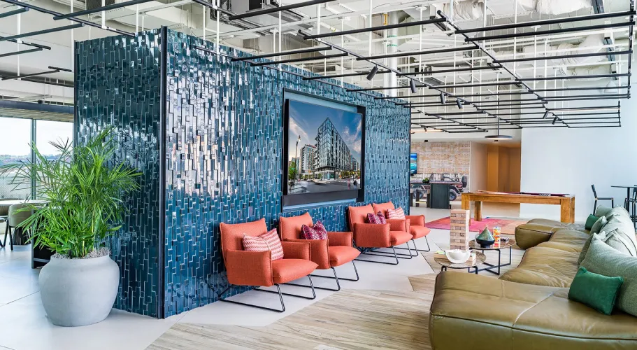 Trendy lounge with bold tiled wall, modern seating, and a large TV as a focal point