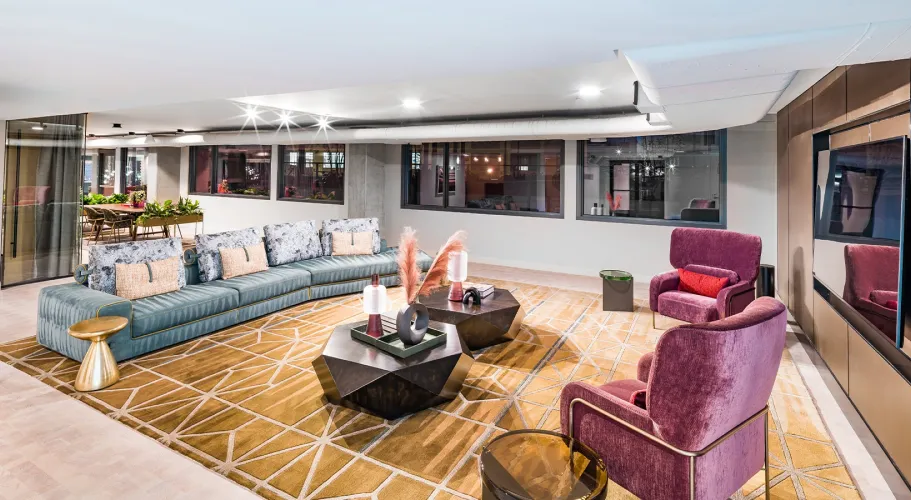 Contemporary indoor lounge with plush sofas, gold accents, and warm lighting for an inviting vibe