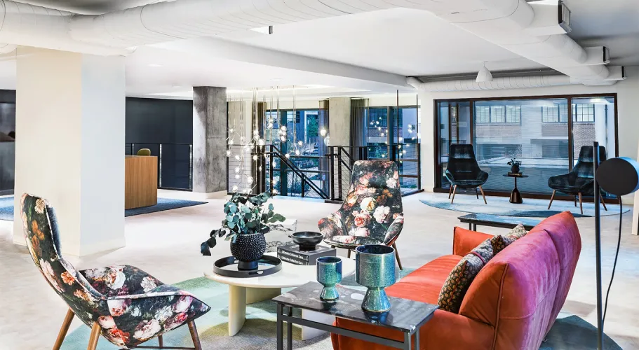 Contemporary lounge featuring colorful furniture, large windows, and bright interior design