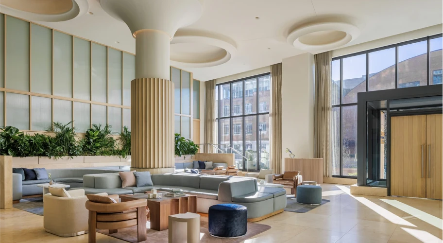 Bright hotel lobby with cozy seating, high ceilings, and natural light from tall windows
