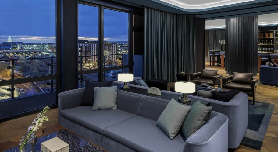 Elegant rooftop bar area featuring modern decor, comfortable seating, and urban nighttime vistas