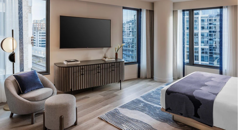 Spacious bedroom with city views, a flat-screen TV, and modern decor