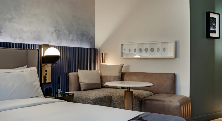 Elegant bedroom seating area with built-in bench, soft cushions, and modern wall art