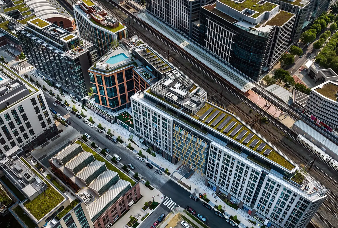 Aerial view of High-rise building complex with solar panels and sustainable green rooftop designs