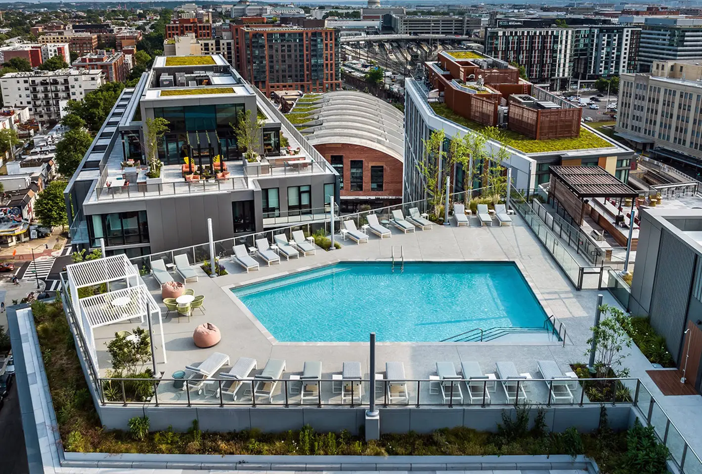 Rooftop pool surrounded by lounge chairs and panoramic city views