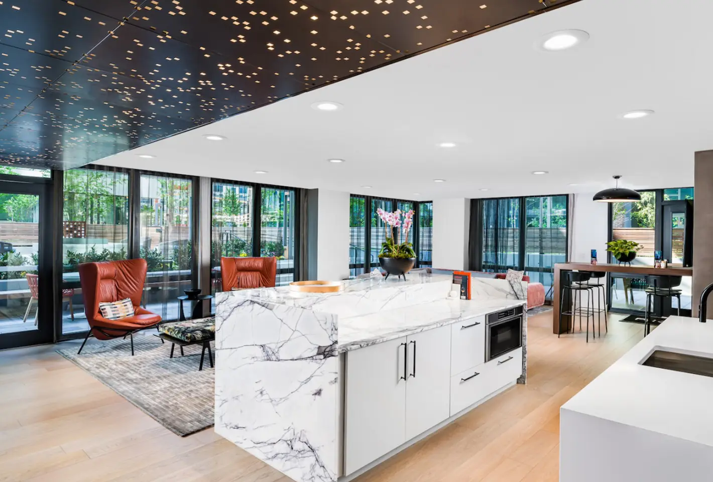 Luxurious open-concept kitchen and lounge with designer ceiling and panoramic glass windows