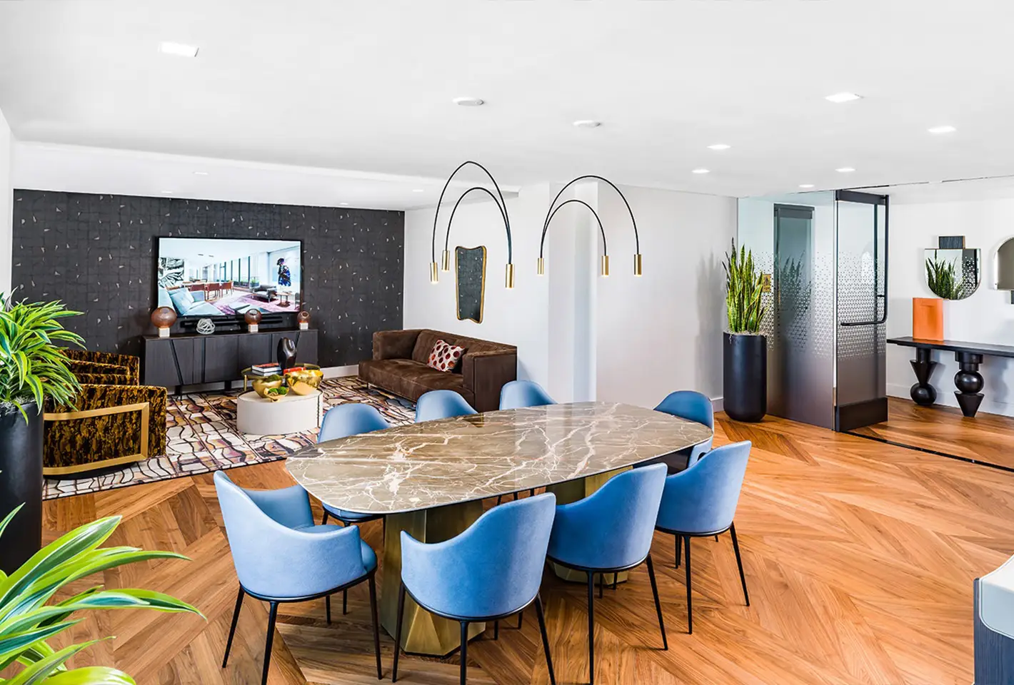Modern lounge space featuring a marble table, blue chairs, and vibrant interior design