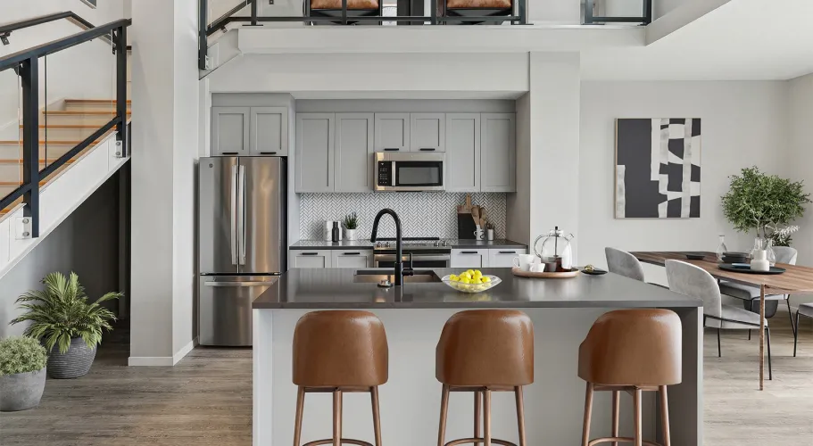 Sleek kitchen design featuring an island, leather stools, and trendy herringbone backsplash