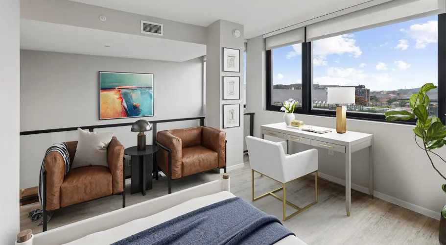 Stylish loft with leather chairs, modern artwork, and natural light from large windows