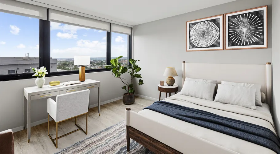 Modern bedroom with stylish decor, expansive windows, and comfortable workspace