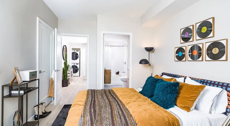 Stylish bedroom with a modern design, colorful bedding, and vinyl records wall art