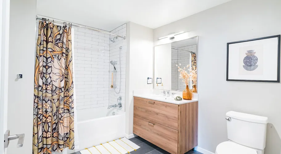 Modern bathroom with a tiled shower, sleek wood vanity, and decorative curtain accents