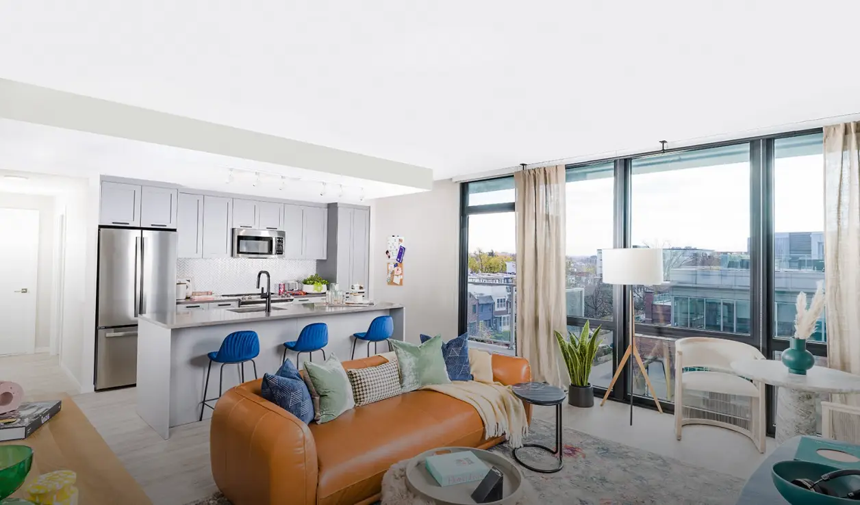 Luxurious apartment interior with leather sofa, open kitchen, and expansive windows overlooking the city