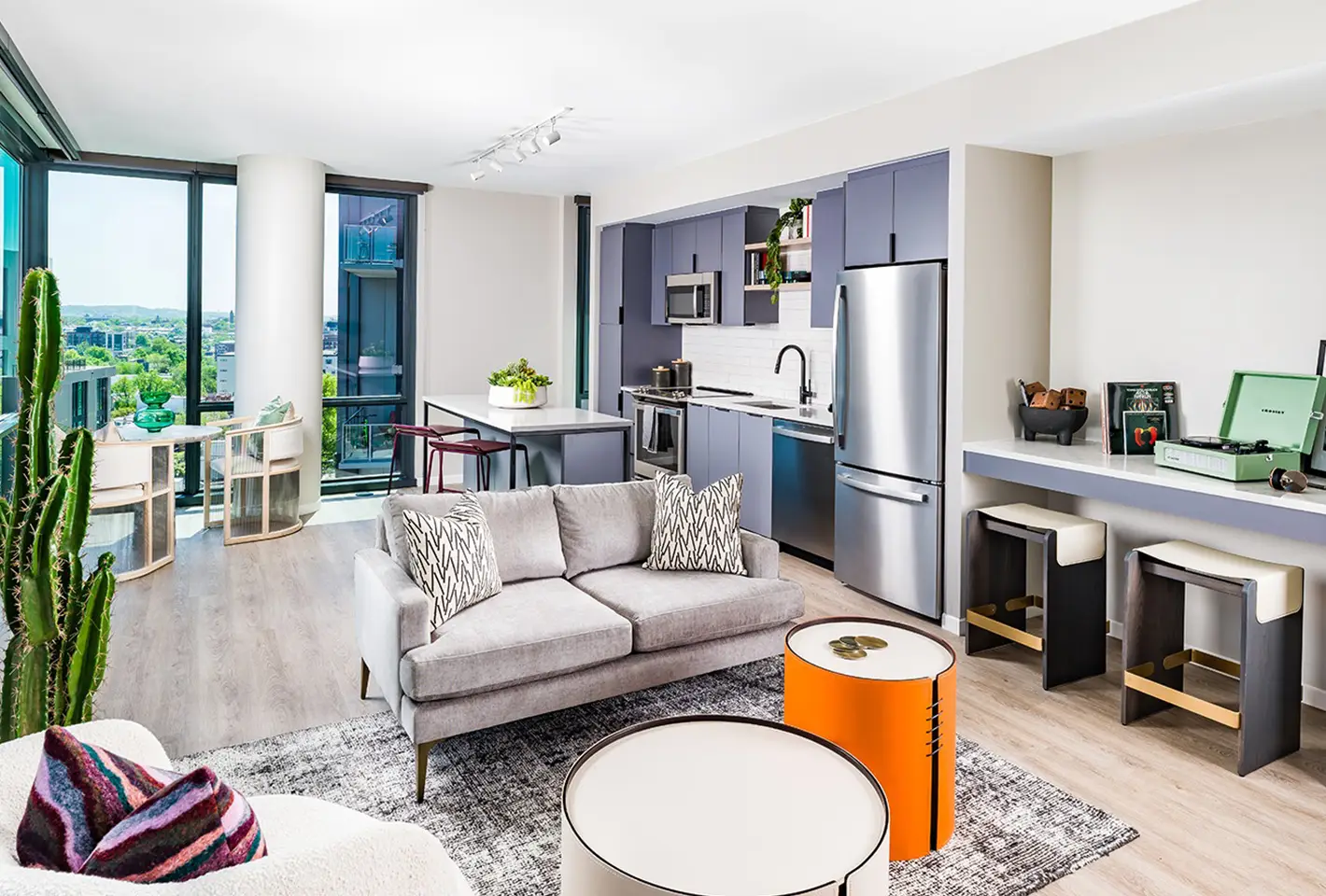 Luxury living room with modern decor, vibrant cushions, and open layout kitchen