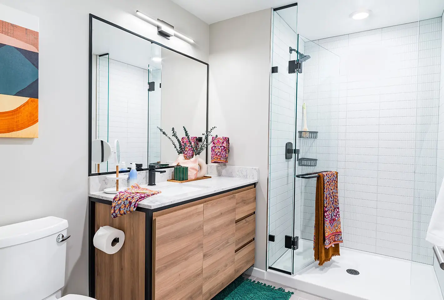 Sleek bathroom featuring artistic decor, bright lighting, and stylish shower fixtures