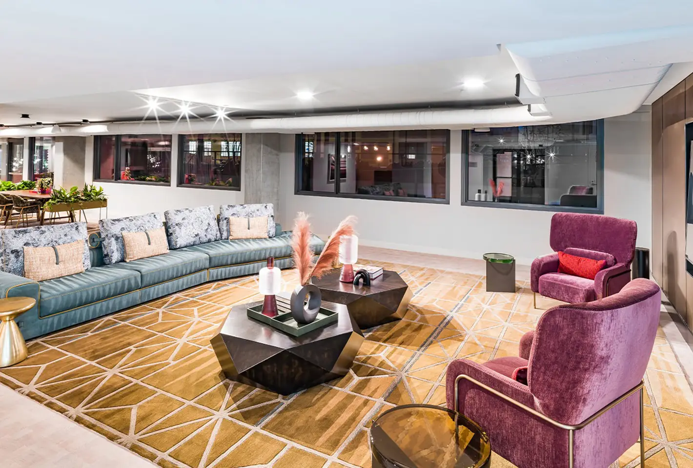 Elegant lounge with vibrant purple chairs, geometric tables, and a stylish sectional sofa