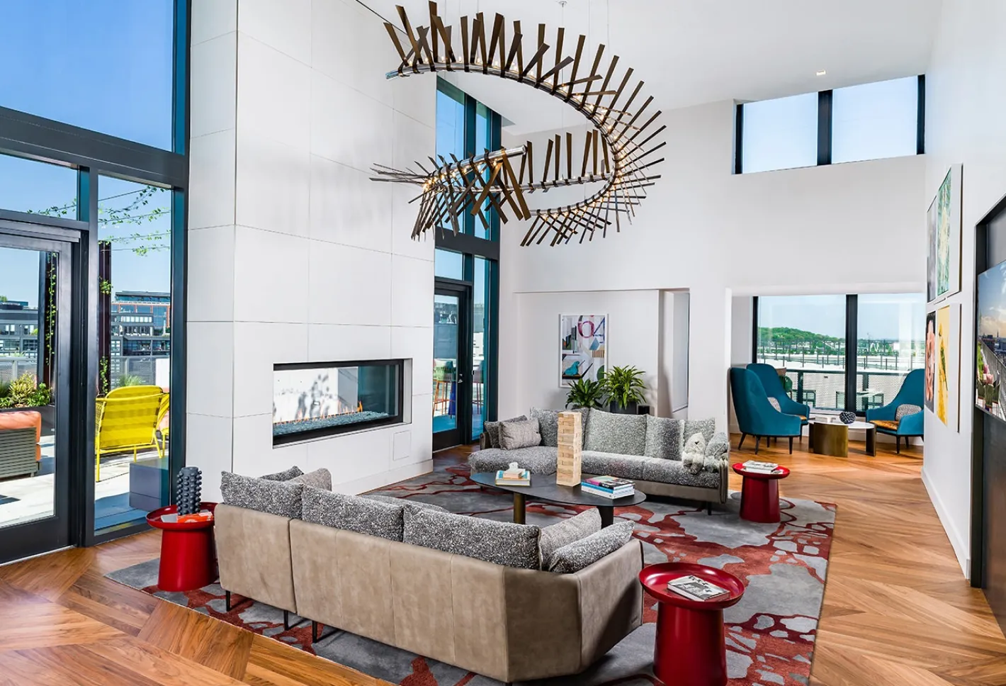 Modern lounge with high ceilings, unique chandelier, and cozy seating arrangement