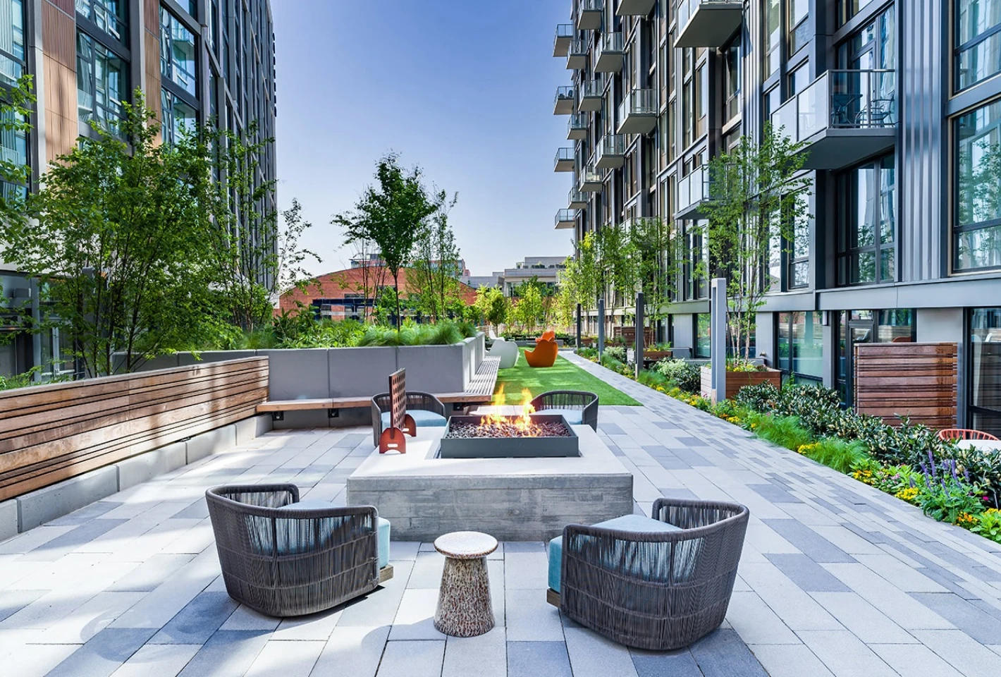 Stylish rooftop lounge with cozy seating, fire pits, and panoramic city views