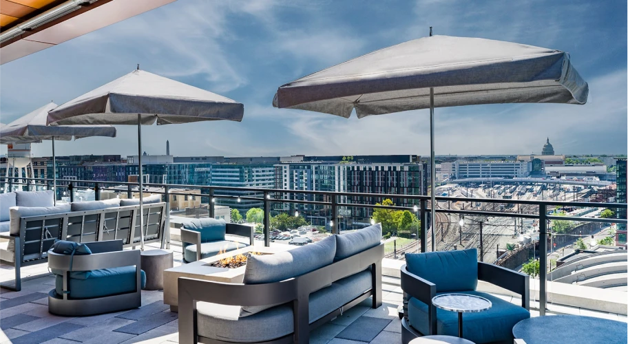 Modern outdoor seating area with a central fire feature and scenic views of Washington DC