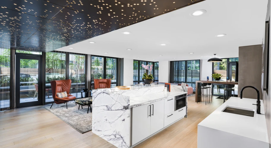 Sophisticated communal kitchen with marble countertops, high-end appliances, and floor-to-ceiling windows