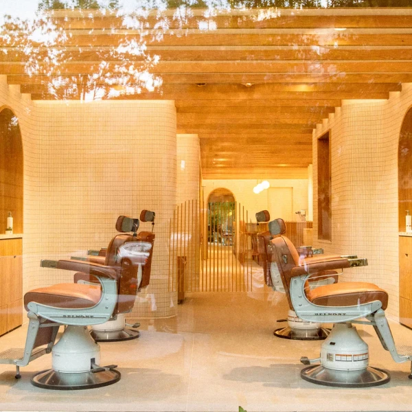 Retro-inspired barbershop interior featuring Belmont chairs and wooden ceiling beams